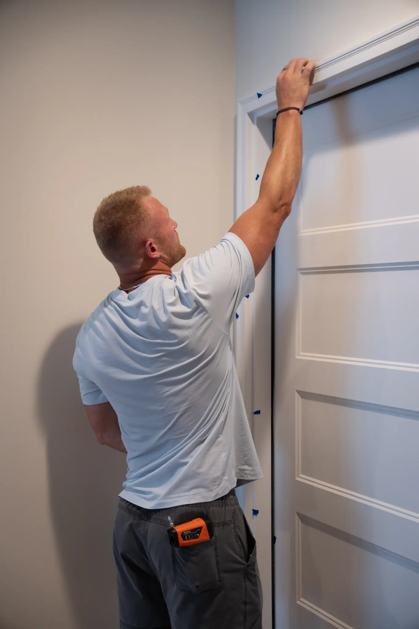 Ensure Quality Construction with a New Home Inspection Person reaching up to touch the top of a door frame.
