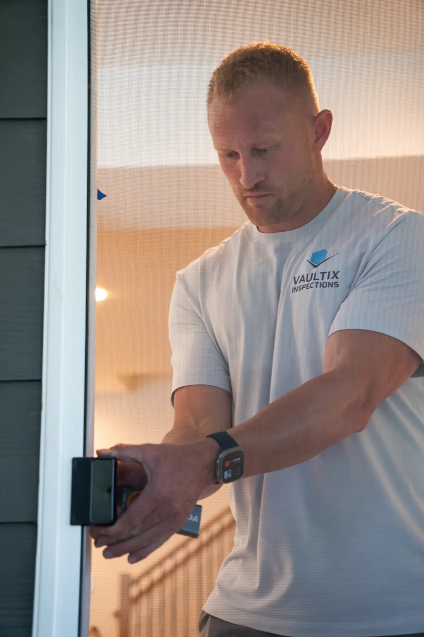 5 Key Tips for Maintaining Your Home’s Foundation Safely A person wearing a Vaultix Inspections shirt checks a home’s exterior door hardware with a handheld device.