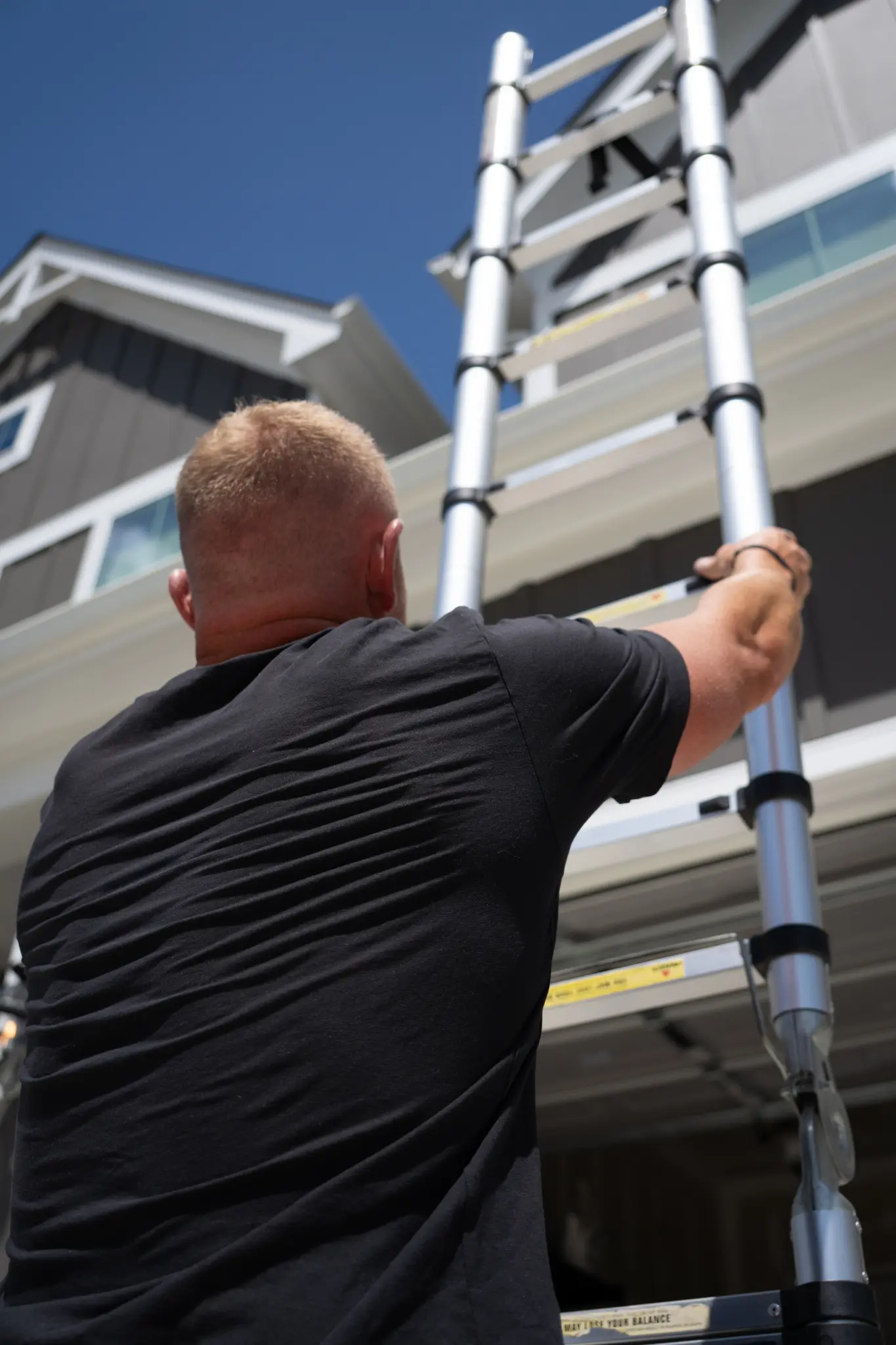 Get a Personalized Home Inspection Quote Today Inspector working at a home's roofline with a ladder
